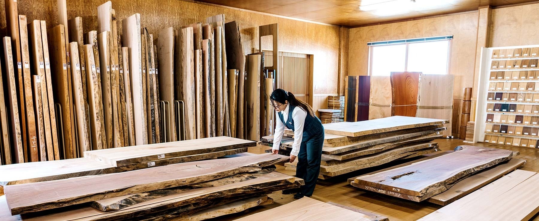 一枚板を整理する女性スタッフ